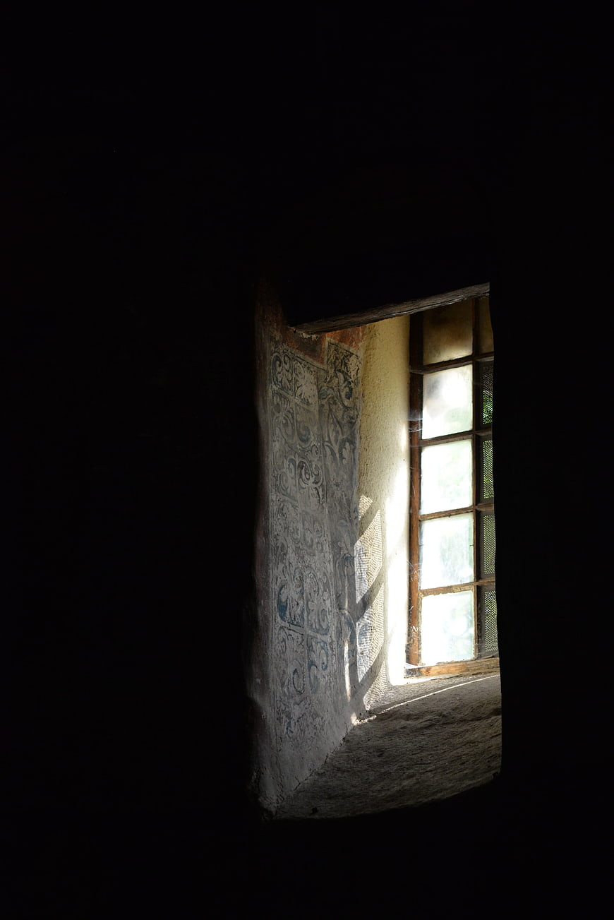 Sunlight streaming through window in old abandoned church interior