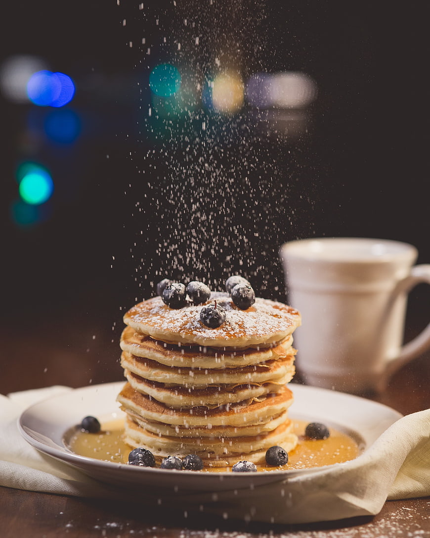 Stack of pancakes with blueberries and powdered sugar
