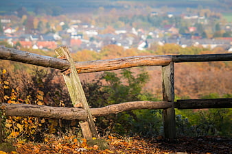 Rustic Wooden Fence Post Overlooking Autumn Village Landscape