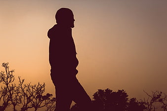Silhouette of a man walking alone at sunset