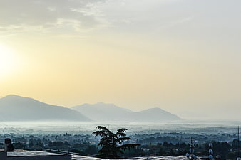 Hazy mountain landscape with city view at sunrise