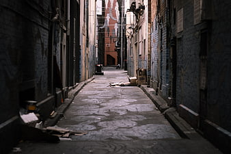 Narrow Urban Alleyway With Graffiti And Debris