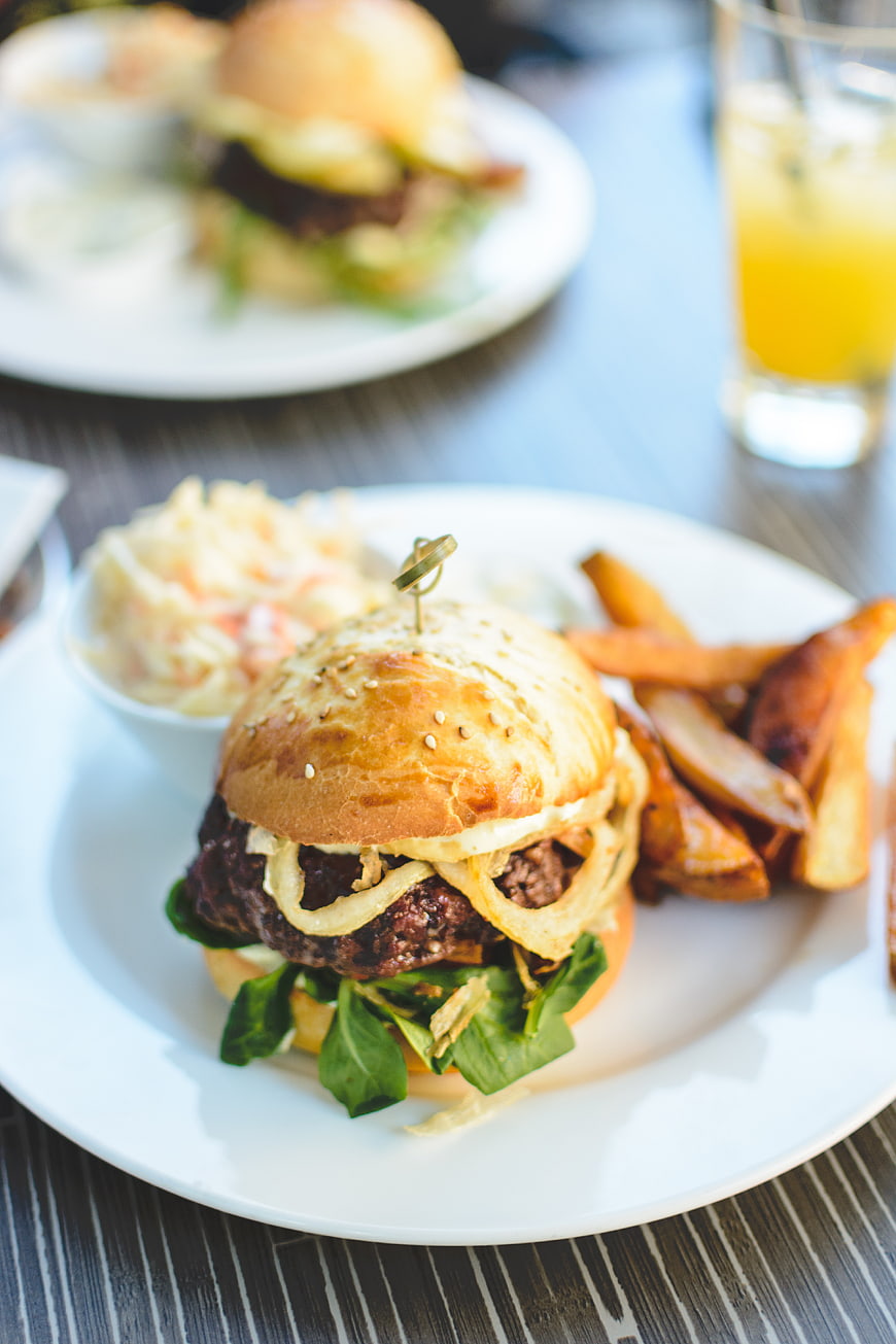 Juicy Beef Burger with Fries and Coleslaw on White Plate