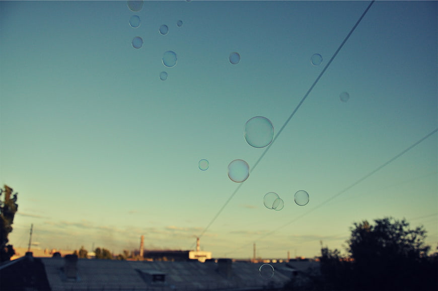Soap bubbles floating against a blue sky at sunset