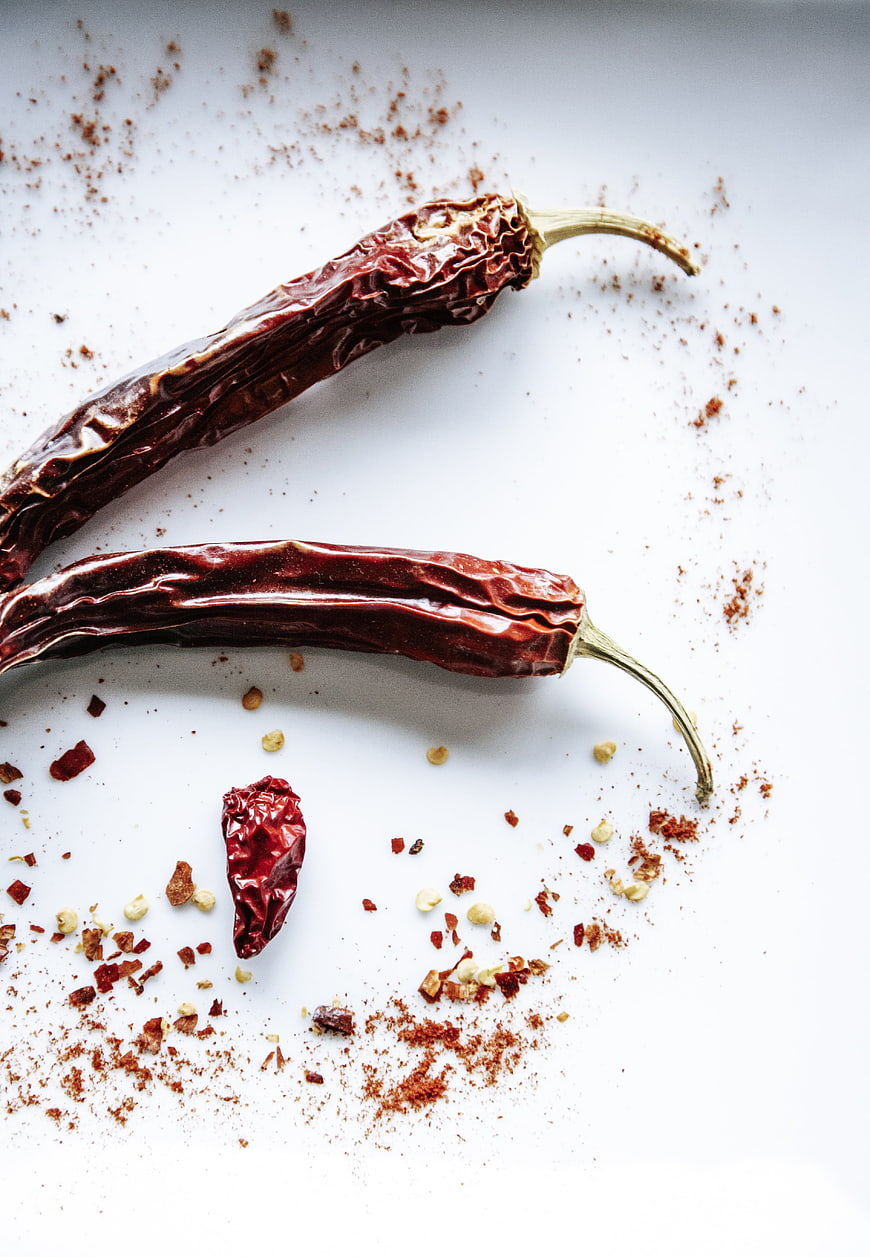 Dried chili peppers and spices on white background