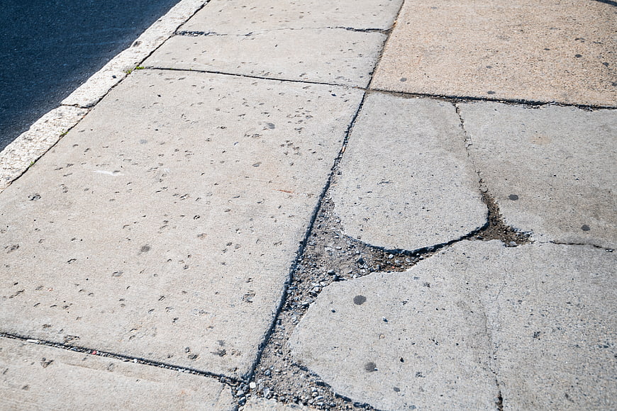 Cracked concrete sidewalk pavement texture background