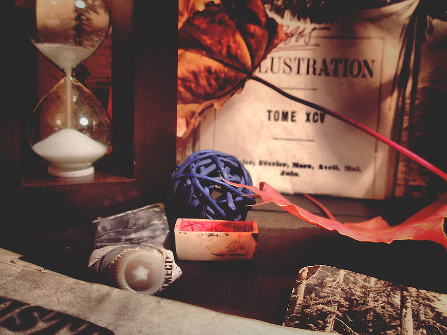 Vintage still life with hourglass, autumn leaf, and old book