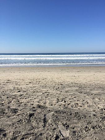 Sandy Beach with Blue Sky and Ocean Waves