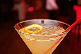 Close-up of a clear cocktail with lemon slice and red straw