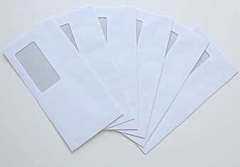White Window Envelopes Fanned Out On Light Gray Background