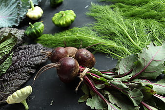 Fresh organic beets with leaves and dill on dark background