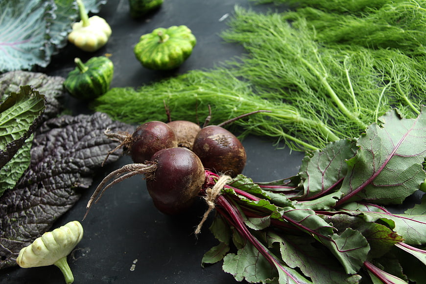 Fresh organic beets with leaves and dill on dark background