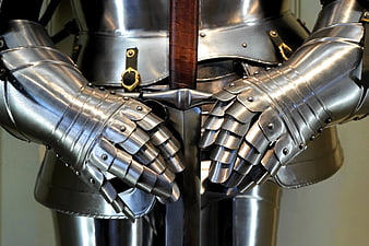 Close-up of medieval knight armor hands gripping sword