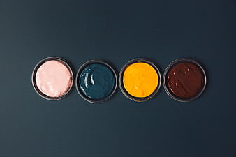 Four Open Paint Pots in Pink, Blue, Yellow, and Brown