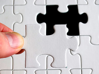 Hand Placing Last White Puzzle Piece into Missing Slot