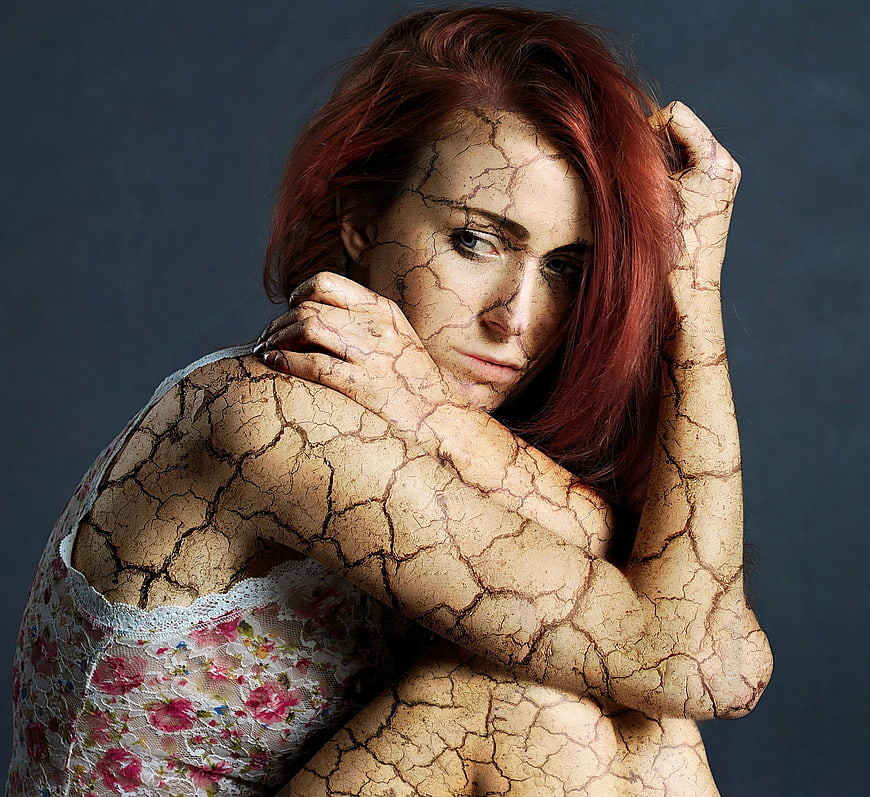 Conceptual Portrait of Woman with Cracked Skin and Red Hair