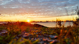 Golden Sunset Over Boston Skyline with Rocky Shoreline