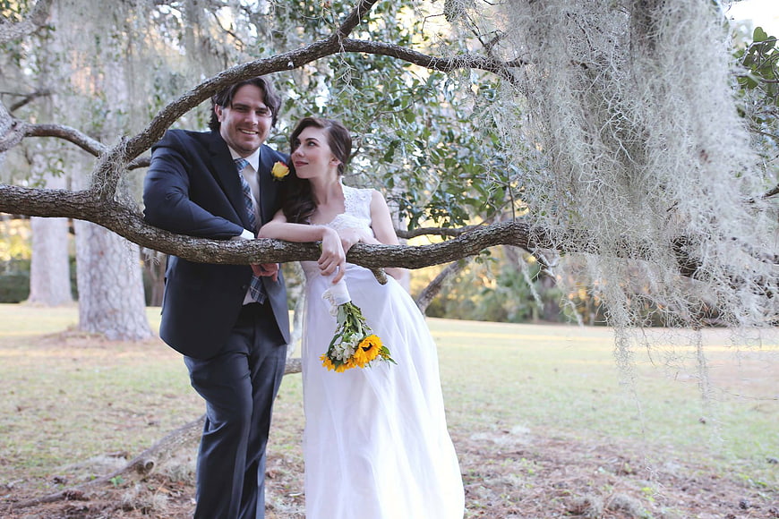 Wedding couple posing under oak tree with Spanish moss