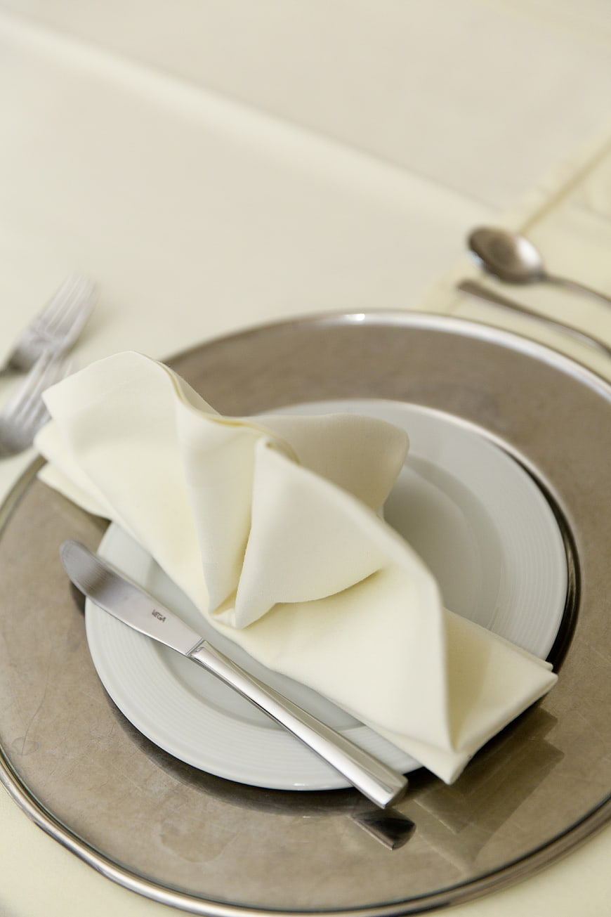 Elegant white table setting with silver charger and folded napkin