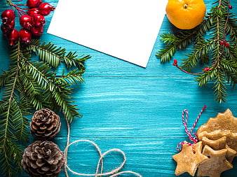 Christmas flat lay with gingerbread cookies, pine branches, and white card on blue wood
