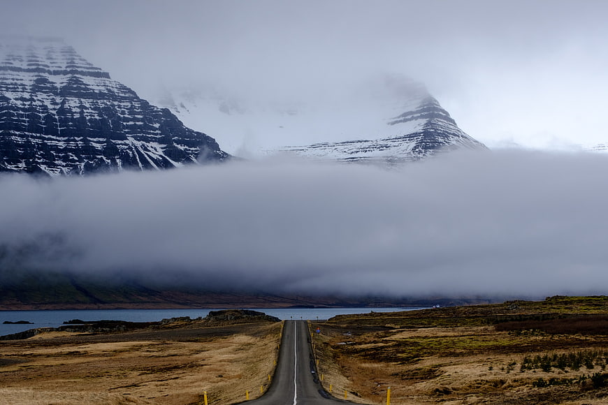 Foggy Road Leading to Snow-Capped Mountains in Iceland