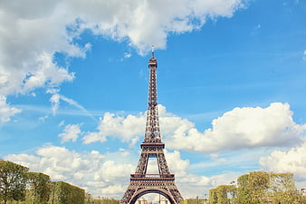 Eiffel Tower in Paris Against Blue Sky with Clouds