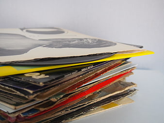 Stack of vintage vinyl records with worn sleeves