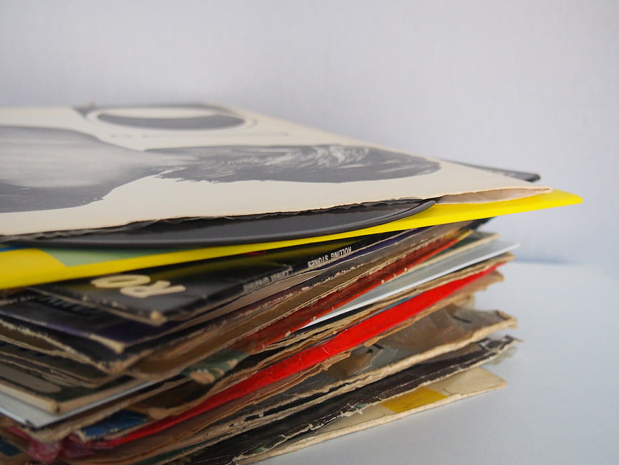 Stack of vintage vinyl records with worn sleeves