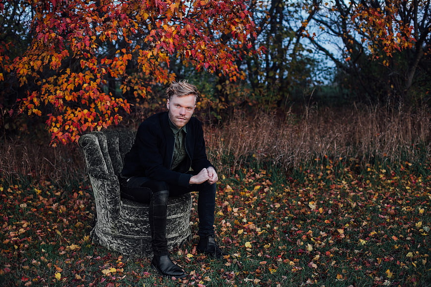 Man Sitting on Velvet Armchair in Autumn Forest