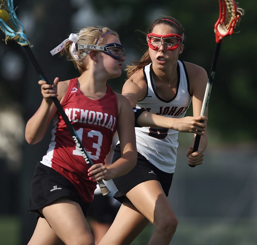Two female lacrosse players competing for the ball