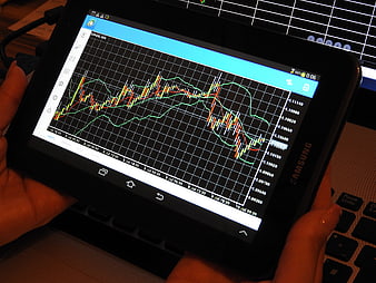 Hands Holding Tablet Displaying Forex Trading Chart