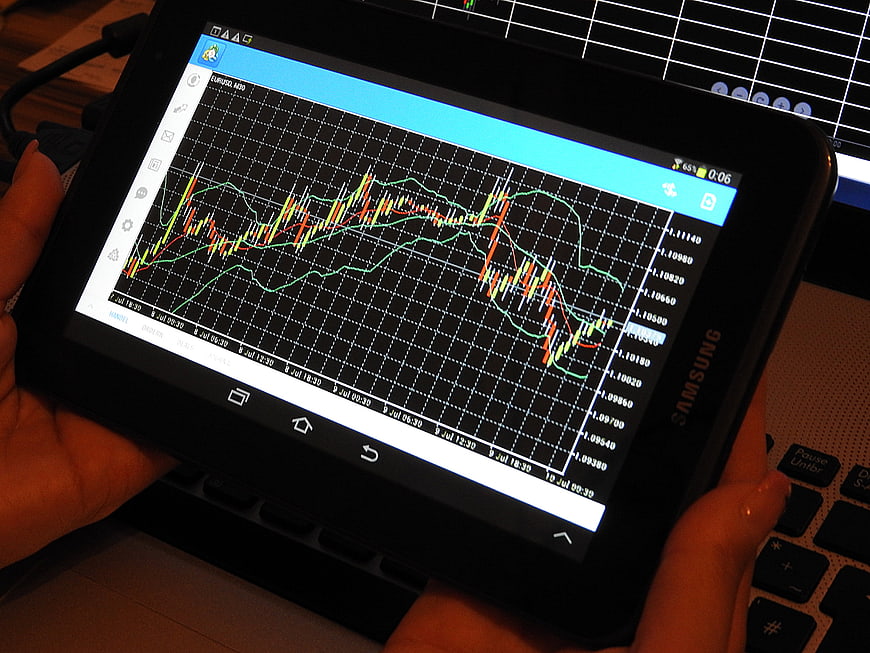 Hands Holding Tablet Displaying Forex Trading Chart