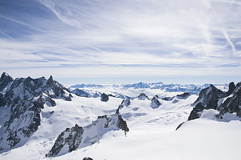 Snowy Alpine Mountain Range with Blue Sky and Clouds