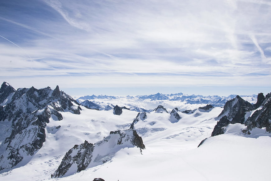 Snowy Alpine Mountain Range with Blue Sky and Clouds