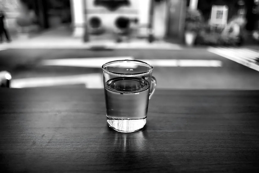 Black and white glass of water on wooden table