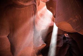 Sunlight beam illuminating smooth sandstone canyon walls