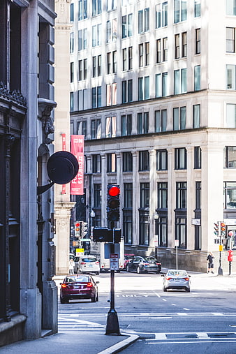 Urban street scene with red traffic light and city buildings