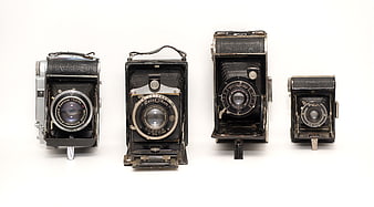 Vintage German folding cameras on white background