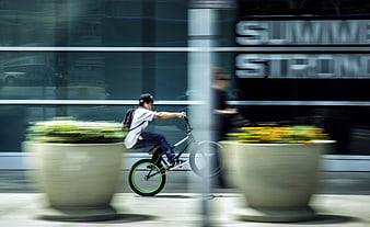 Man riding BMX bike with motion blur in urban setting