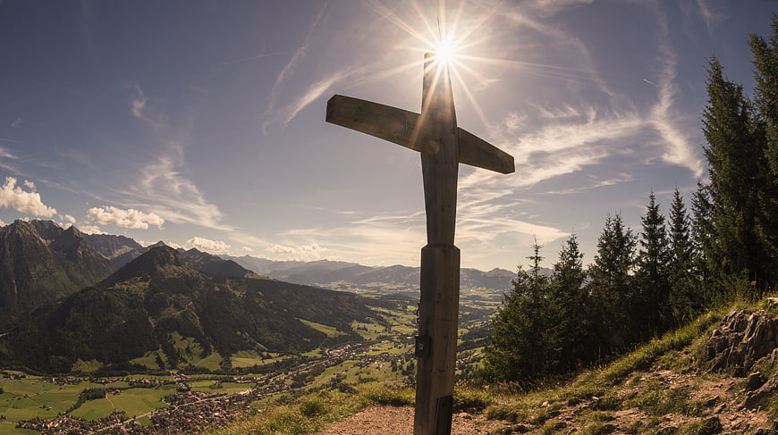 Wooden Summit Cross with Sunburst Over Alpine Valley