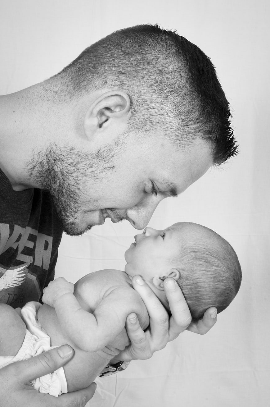 Black and white portrait of father holding newborn baby