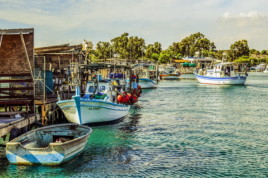 Fishing boats docked in a harbor with clear turquoise water