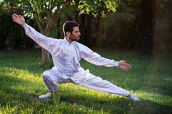 Man practicing Tai Chi in a sunlit park