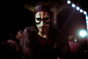 Man in dark mime makeup with red stripes at night