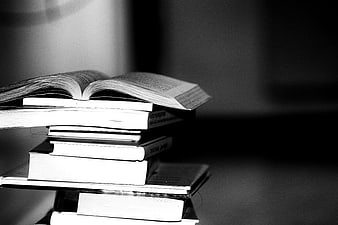 Black and white stack of books with open pages