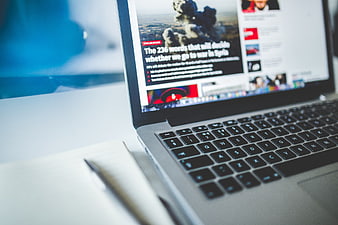 Laptop displaying news article about war in Syria on desk