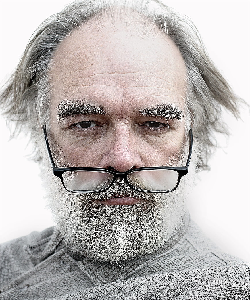 Close-up portrait of elderly bearded man with glasses