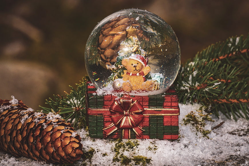 Christmas Snow Globe With Teddy Bear And Pinecone On Snow