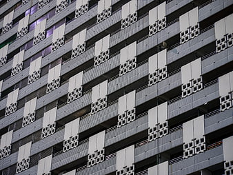 Modern Concrete Building Facade with Geometric Balcony Patterns