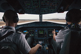 Two pilots in airplane cockpit on runway